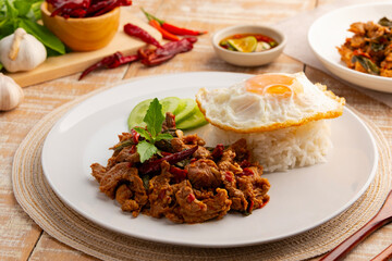 Stir fried sliced Beef with dry chilli and Holy Basil and cooked thai rice topped with fried egg in...