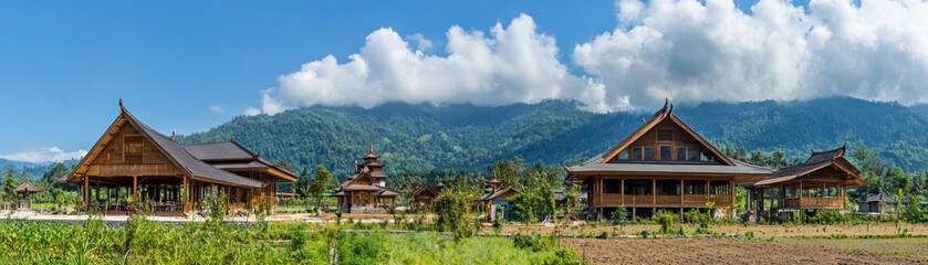 Fototapeta premium Scenic view of traditional architecture against a backdrop of mountains and blue skies.