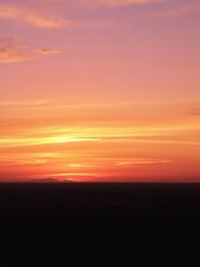 Obraz premium Vibrant gradient of golden, pink, and purple hues in a beautiful sunset over the horizon, dusk, golden, sunset