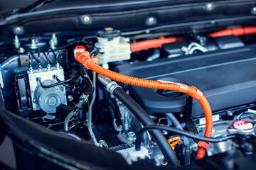 Selective focus to hybrid automotive industry part of modern new car engine room, Machine show all parts and open hood. Engine and electric motor room of new car.