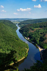 Saar river surrounded by green trees on a sunny spring day in Germany.