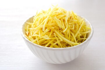 ginger slices in white ceramic bowl on white background