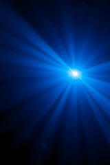 Obraz premium A bright blue light source emitting rays in a dark environment, creating a dramatic and atmospheric effect. The light beams radiate outward, enhancing the sense of depth and mystery.