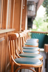 Beautiful and Elegant Wooden Bar Stools Featuring Green Cushions on a Cozy Balcony Setting