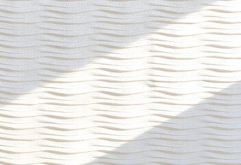 Obraz premium Textured white wall with wavy patterns creating soft, natural look. interplay of light and shadow enhances visual appeal, adding depth and dimension to surface
