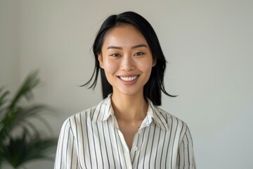 Fototapeta premium Happy Asian girl in office attire smiles sweetly.