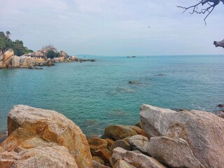 a quiet beach view with large rocks