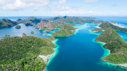 A remote lagoon, surrounded by limestone islands, protects a vibrant and diverse coral reef in Wayaq Island, Raja Ampat, Indonesia.