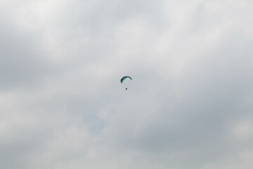 One parachute of paragliding on cloudy sky background