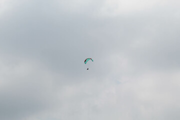 One parachute of paragliding on cloudy sky background