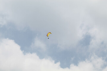 One parachute of paragliding on cloudy sky background