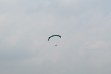 One parachute of paragliding on cloudy sky background