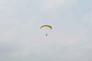 One parachute of paragliding on cloudy sky background