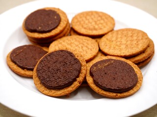 Close up image of chocolate biscuits on a white plate. Delicious and crispy chocolate biscuits, perfect for a sweet snack or dessert