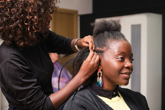 Hairdresser making crochet braids to a client in a hair salon