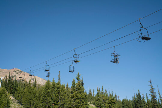 A mountain bike attached to a ski lift moves up the mountain.