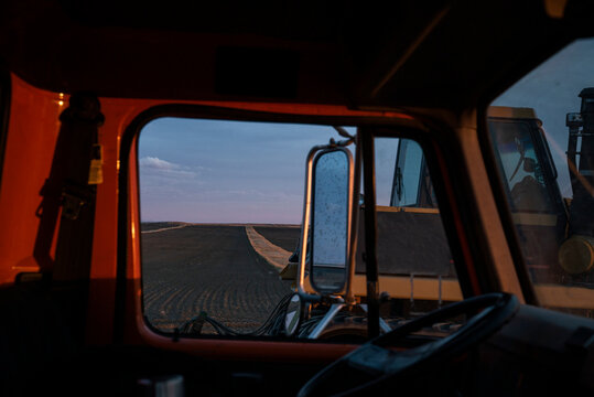 Long row crops framed through the window of an old truck.