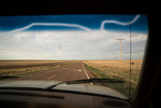 A rural road shot through a cracked truck windshield.