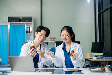 Fototapeta premium Two Asian doctors in a modern clinic, focusing on patient care, teamwork, and healthcare analysis.