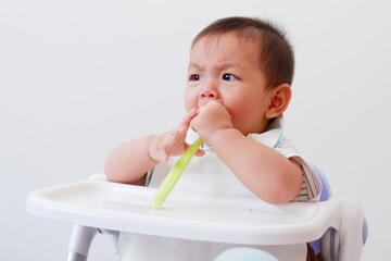 Cute baby sitting eating and smiling.