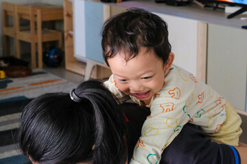 Obraz premium The boy rides on his mother's back.