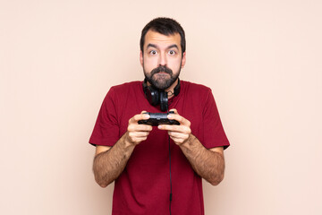 Man playing with a video game controller over isolated wall