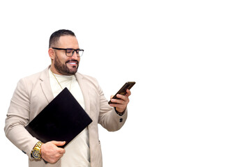 Latin man in a smart suit with a laptop in his hand, looking very attentively at his phone. Insurance business. Copy space. White background.