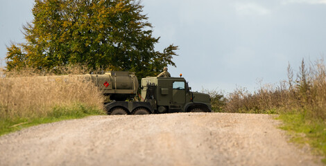 Fototapeta premium British army Oshkosh 6x6 wheeled tanker Logistic Support and Transport Regiments pulling a fuel tanker on a dirt road