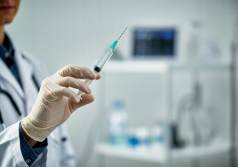 Healthcare professional holds a syringe in a clinical setting ready for vaccination during daylight hours