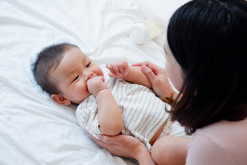 A mother is brushing the teeth of a baby or young child.