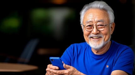 Obraz premium Man in a blue shirt is smiling and holding a cell phone. He is happy and enjoying himself