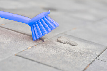 Blue brush for cleaning. Stone tiles, paving