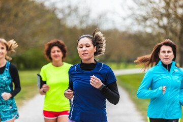 Fototapeta na wymiar Group of women running together in a park