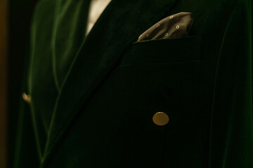 Male torso in green velvet jacket with handkerchief in pocket. Style and fashion. Close-up.