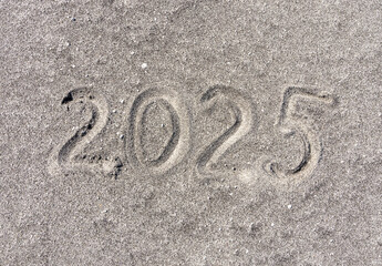 Business concept of 2025 new year symbol. Concept 2025 happy new year written on beautiful ocean sand beach. Beautiful ocean sand beach background, copy space. Business 2025 happy new year concept.