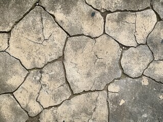 Obraz premium Cracked surface showing dry, weathered ground with a rough texture.