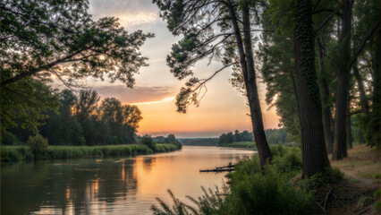 Obraz premium Riverbank at sunset with a calming mood and reflections of the sunset on the water framed by trees