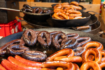 vendor fries meat and sausage on the grill in the city center at the Christmas market in Gdansk Poland