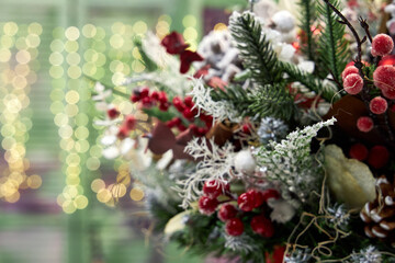 Christmas bouquet of pine needles with cones on green background with bokeh