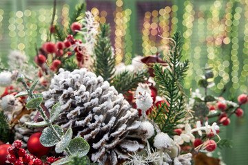 Christmas bouquet of pine needles with cones on green background with bokeh