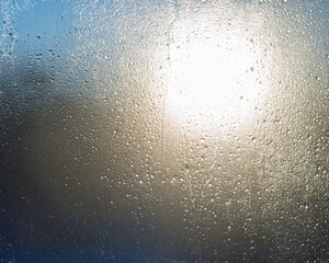 background frozen drops on the window glass against the background of the contour light from the sun
