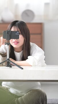 Image of a video distributor taking a picture Vertical video of a cute young woman waving to the camera, bye-bye~!