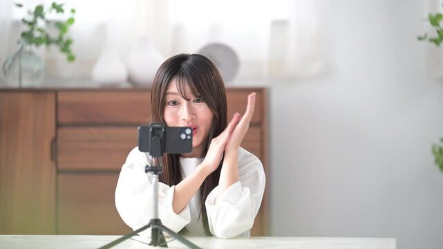 Image of video distributor taking a picture Cute young woman waving to the camera, slow video of bye-bye~!