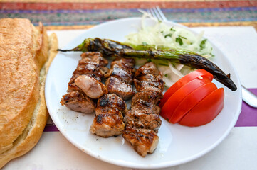 Roast meat served on a plate in a restaurant. Lamb skewers. Grilled meat.