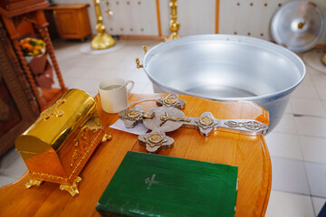 a baptismal font and a table with attributes for the sacrament of baptism in the church. Christian traditions.