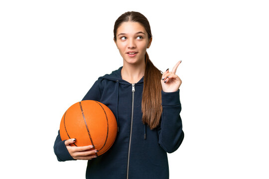 Teenager caucasian girl playing basketball over isolated background thinking an idea pointing the finger up