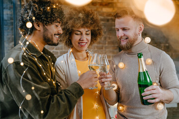A group of friends raising glasses of champagne and one of them making a toast indoor