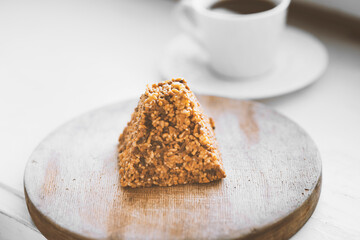 Cup of coffee and a piece of cake on a wooden board