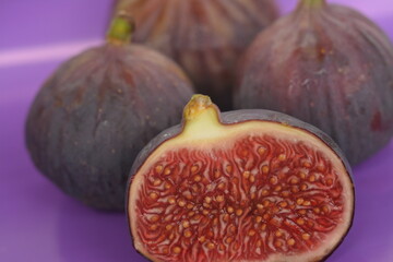 Whole and cut figs on a purple background