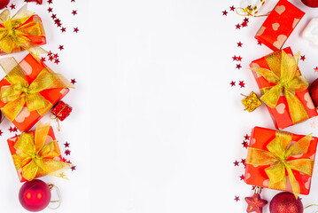 Red and gold christmas baubles, red gift boxes at white background. Merry Christmas greeting card,
